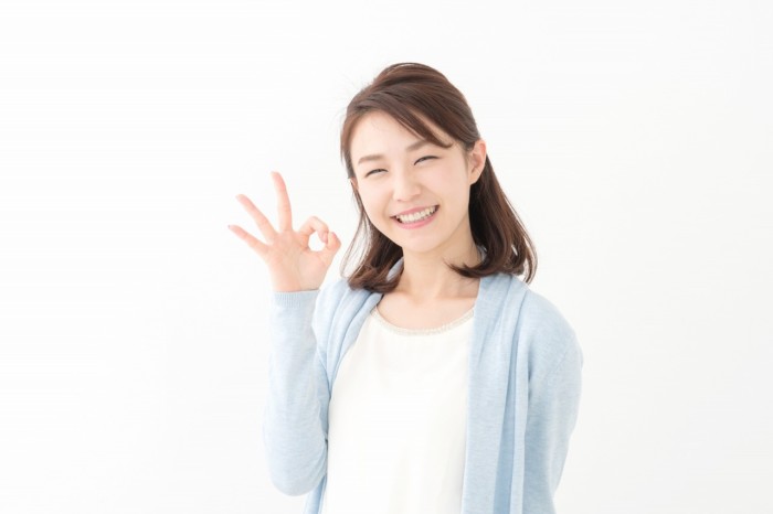 手で丸をつくる女性